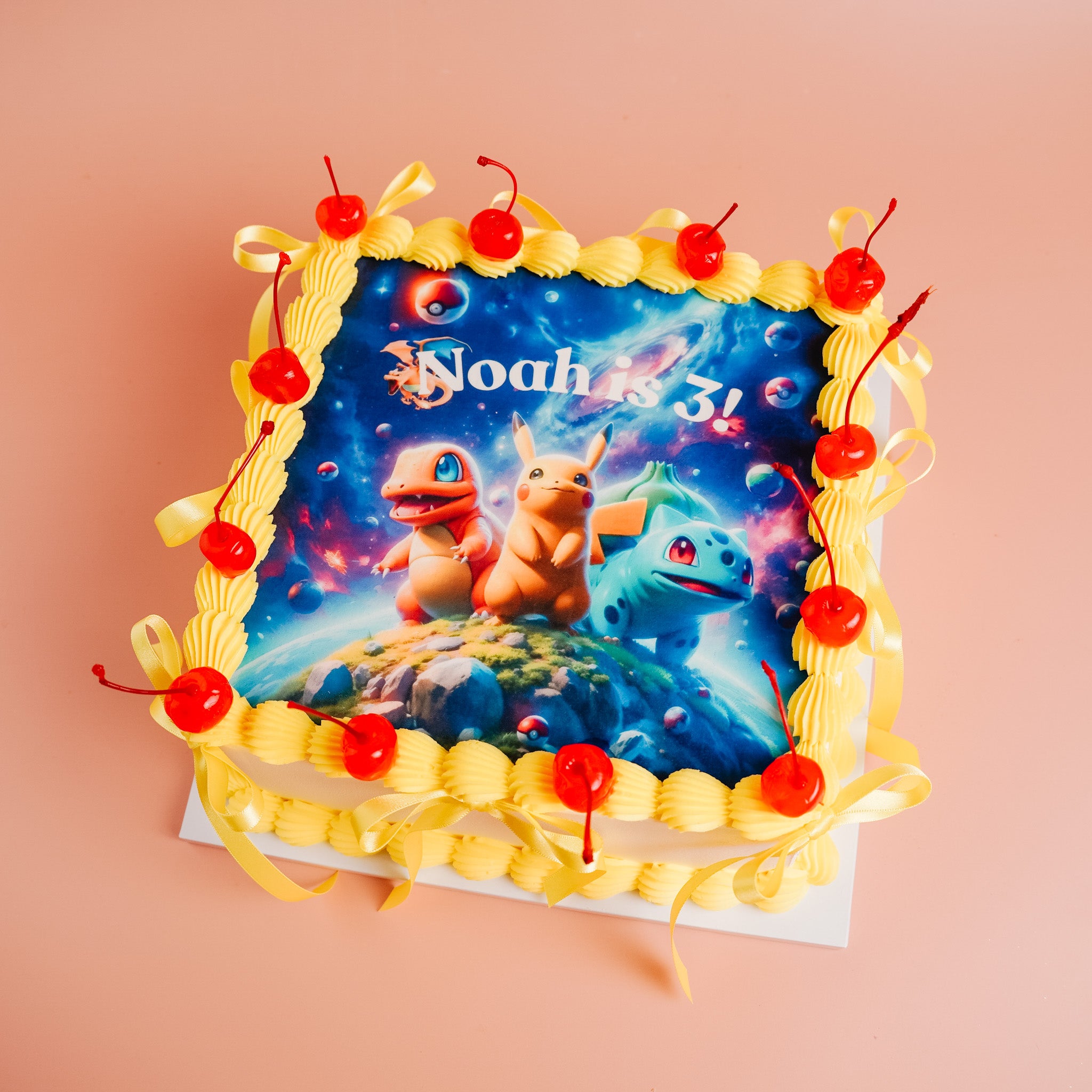 A square Pokémon-themed birthday cake with three cartoon Pokémon characters and &