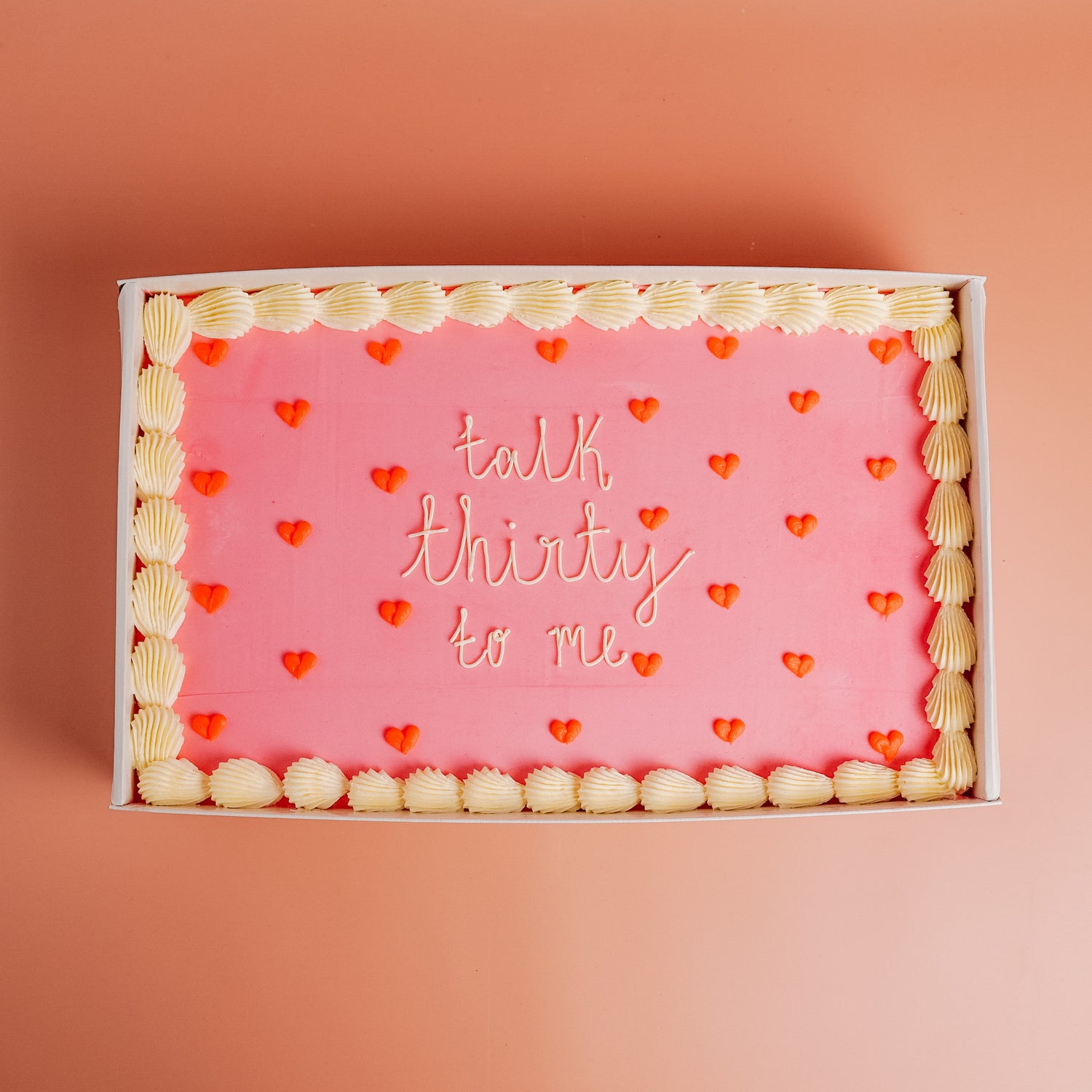 Pink cake with heart decorations and &