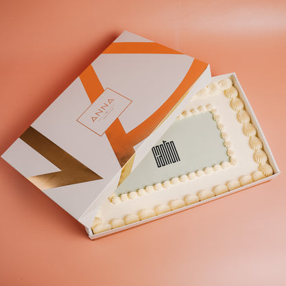 Open cake box with a cake inside with a copany logo on a peach background